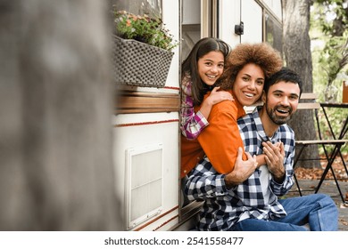 Family of three with parents and daughter traveling together by van motor home home on wheels hugging embracing and looking at camera. Trip voyage with family - Powered by Shutterstock