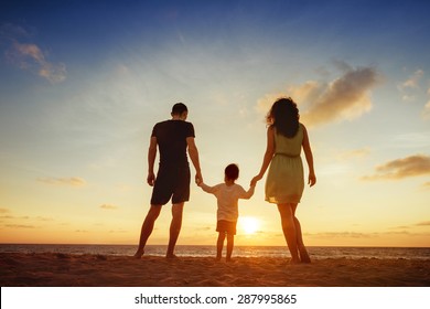 Family Of Three Person Is Standing On Sunset And Sea Backdrop