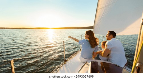 Family Of Three Sailing On Yacht Sitting On Sailboat Deck Looking At Sunset At Seaside. Dream Vacation Concept. Free Space - Powered by Shutterstock