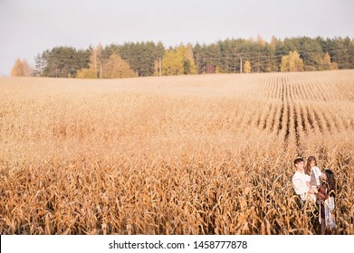 Family Of Three Standing In A Corn Field