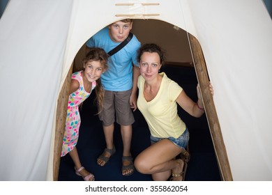 Family of three are standing into tepee in National Museum of the American Indian.