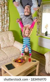 Family Of Three Upside Down On Green Room At Inverted House