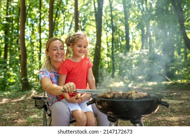 Family time concept with mother making barbecue with her daughter in the nature - Powered by Shutterstock