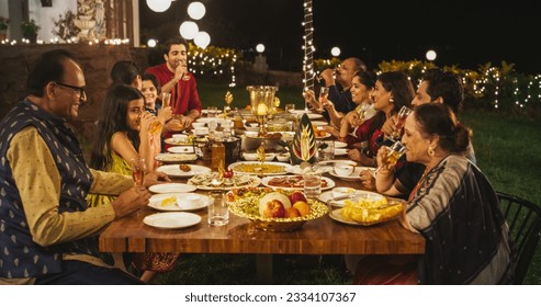 Family Time and Good Happy Memories: Indian Relatives of All Ages Gathered Together Around Dinner Table on a Backyard Garden Party to Eat Traditional Food. Moment of Pure Love and Sharing - Powered by Shutterstock