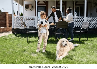 family time, happy african american boy holding football near parents and dog on backyard of house - Powered by Shutterstock