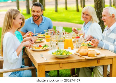 Family Time. Happy Family Of Five People Communicating And Enjoying Meal Together While Sitting At The Dining Table Outdoors 