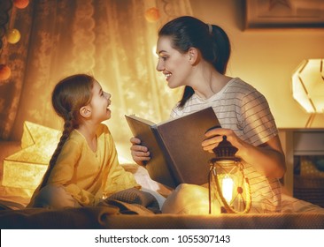 Family Time. Pretty Young Mother Reading A Book To Her Daughter. Happy Time At Home.