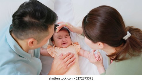 Family Time - Top View Of The Parents Lying On Bed Are Comforting Crying Baby And Touching Infant