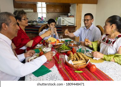 family toasts with tequila shots during a traditional Mexican dinner celebrating national holidays. A family toasting to celebrate Independence Day in Mexico. - Powered by Shutterstock