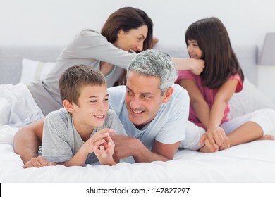 Family Together On Bed At Home