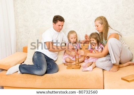 Family together playing dominoes on the couch