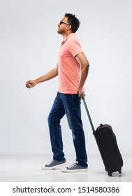 Family, Tourism And Vacation Concept - Smiling Indian Man In Polo Shirt With Travel Bag Over Grey Background