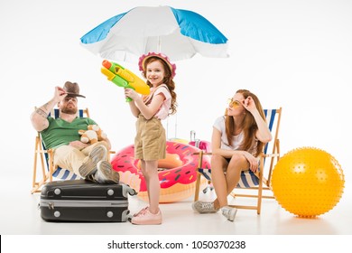 Family Of Tourists With Sun Loungers, Sunshade, Flotation Ring And Water Gun Isolated On White