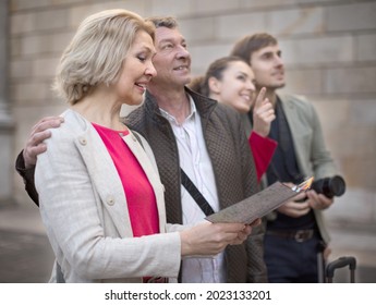 Family Of Tourists View Map And Travel In European City