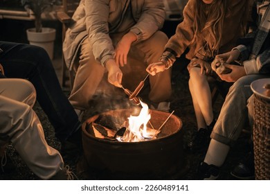 Family trailer travel. Children,brother sister,mom dad fry sausages on fire, eat hot dogs. Evening picnic in nature.Holiday barbecue BBQ food.Vacation weekend dinner.Road lunch.Camper,house on wheels. - Powered by Shutterstock