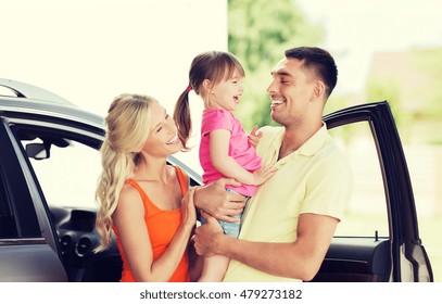 Family, Transport, Leisure And People Concept - Happy Man, Woman And Little Girl With Car Laughing At Home Parking Space