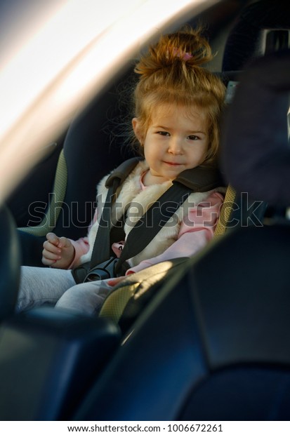 family, transport, road trip and people\
concept - portrait girl sitting in the car\
seat\
