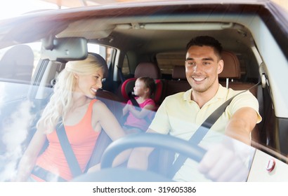 Family, Transport, Safety, Road Trip And People Concept - Happy Man And Woman With Little Child Driving In Car