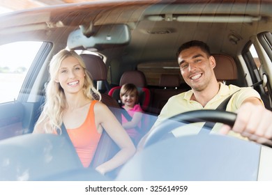 Family, Transport, Safety, Road Trip And People Concept - Happy Man And Woman With Little Child Driving In Car