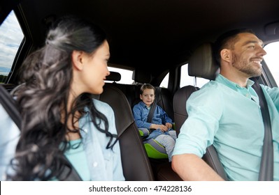 Family, Transport, Safety, Road Trip And People Concept - Happy Man And Woman With Little Child Driving In Car