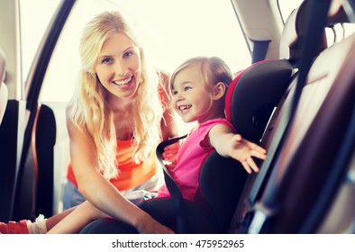 family, transport, safety, road trip and people concept - happy mother fastening child with car seat belt - Powered by Shutterstock