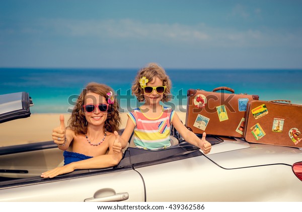 Family travel by car to the sea. Woman and\
child having fun. Mother and daughter in cabriolet. Happy family\
outdoors. Summer vacation and travel\
concept