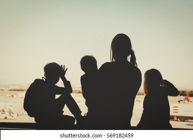 Family Travel- Mother With Three Kids Looking At Planes In Airport