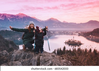 Family Travel Slovenia, Europe. Mother With Son On Sunset On Bled Lake. Winter Landscape. Top View On Island With Catholic Church In Bled Lake With Castle And Alps Mountains In Background.