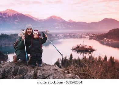 Family Travel Slovenia, Europe. Mother With Son On Sunset On Bled Lake. Winter Landscape. Top View On Island With Catholic Church In Bled Lake With Castle And Alps Mountains In Background.