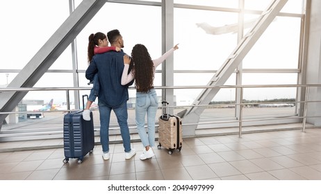 Family Travel. Young Parents With Little Daughter Standing At Airport Terminal, Rear View Of Mom, Dad And Female Child Looking Out Of Window While Waiting For Flight Boarding, Panorama