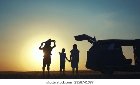 family traveling by car. family watching sunset silhouette next to the car in the park. happy family kid dream concept. people in the park. lifestyle family car camping resting in nature