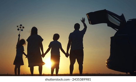 family traveling by car. family watching the sunset silhouette next to the car in the park. family holding lifestyle hands play pinwheel. people in park. family car camping resting in nature - Powered by Shutterstock