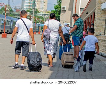 Family Traveling By Train. Family Members Have Luggage, Trolleys And Are Getting Ready To Get On The Train. Romania, Constanta. August, 27, 2021