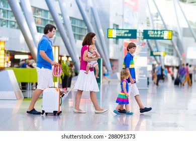 Family Traveling With Kids. Parents With Children At International Airport With Luggage. Mother And Father Hold Baby, Toddler Girl And Boy Flying By Airplane. Travel With Child For Summer Vacation.