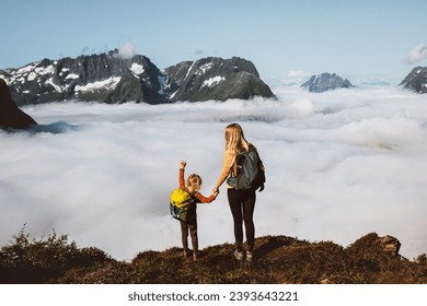 Family traveling in mountains mother and daughter hiking together in Norway, adventure trip outdoor active vacations parent and kid girl with backpack climbing above clouds - Powered by Shutterstock