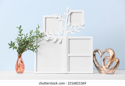 Family Tree With Photo Frames, Vase And Decor On Table Near Blue Wall