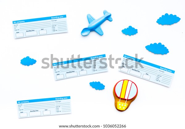 Family trip concept. Airplan\
toy, air balloon cookie, airplan tickets on white background top\
view