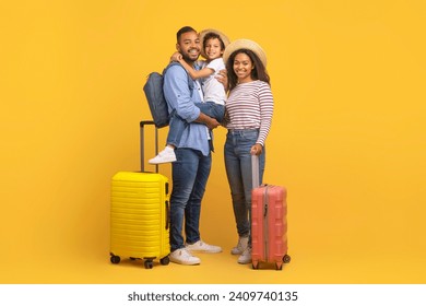 Family Trip Concept. Happy African American Parents Travelling With Their Little Son, Black Mother, Father And Preteen Male Kid Posing Together With Luggage Suitcases Over Yellow Background In Studio - Powered by Shutterstock