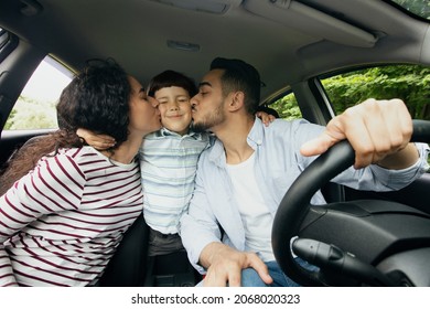 Family Trip. Happy Arab Parents Kissing Their Son While Riding Car Together, Loving Middle Eastern Mom And Dad And Their Male Child Enjoying Automobile Travels, Closeup Shot Inside Of Vehicle