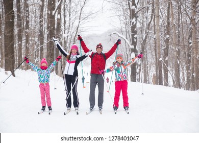 Family With Two Children Cross-country Skiing In The Winter Forest In The Snow