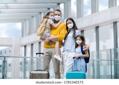 Family With Two Children Going On Holiday, Wearing Face Masks At The Airport.