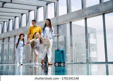 Family With Two Children Going On Holiday, Walking At The Airport With Luggage.