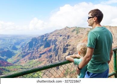 Family Of Two Enjoying Waimea Canyon At Viewpoint, Kauai Island, Hawaii