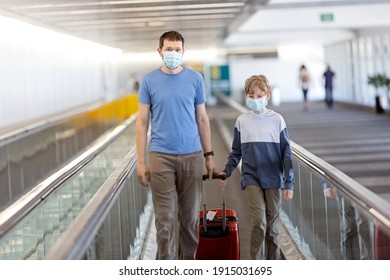 family of two, father and son, in face masks standing with the luggage in the airport, travel during coronavirus pandemic concept - Shutterstock ID 1915031695