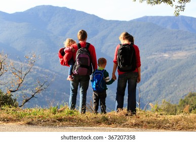 Family With Two Kids Hiking In Mountains