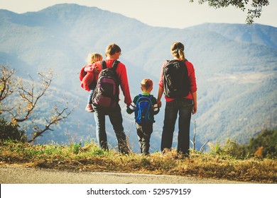 Family With Two Kids Hiking In Mountains