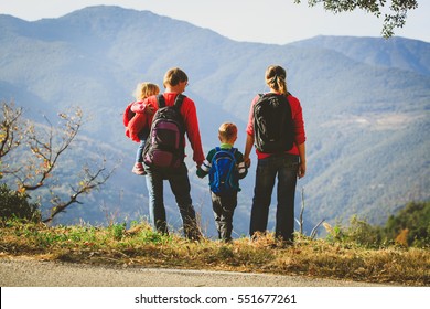 Family With Two Kids Hiking In Mountains