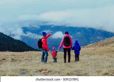 Family With Two Kids Hiking In Winter Mountains