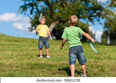 Family - two little boys playing badminton outdoors