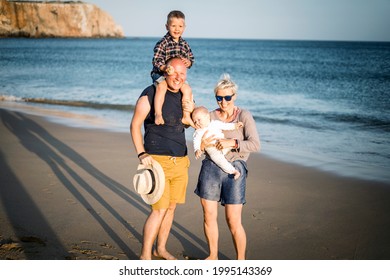 The Family With Two Small Boys Enjoying Time On The Beach, Algarve, Portugal